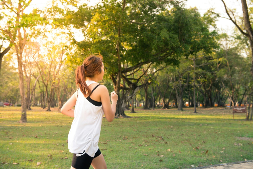 Mulher praticando corrida em parque ao ar livre, conceito saúde e bem-estar