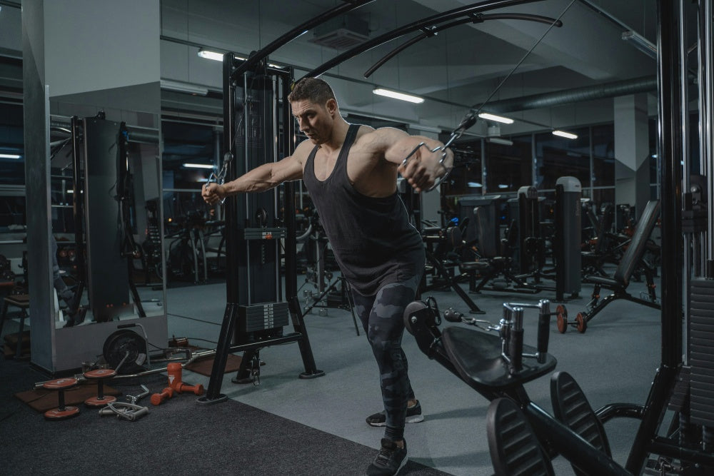 Homem malhando no aparelho de cross over em academia moderna, treino de musculação e desempenho